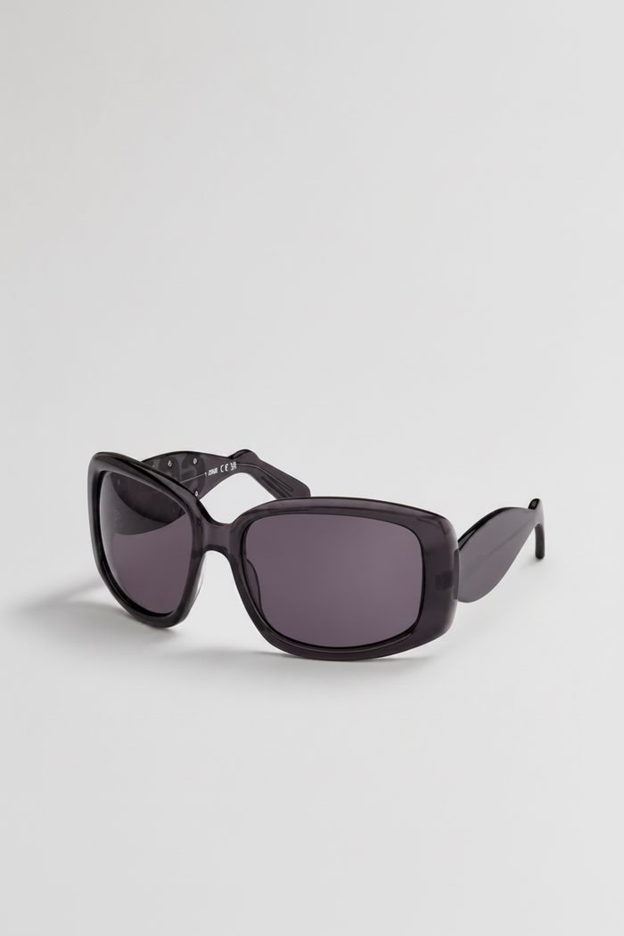 Oversized square sunglasses with a glossy black acetate frame and dark gray lenses, shown on a light gray background.