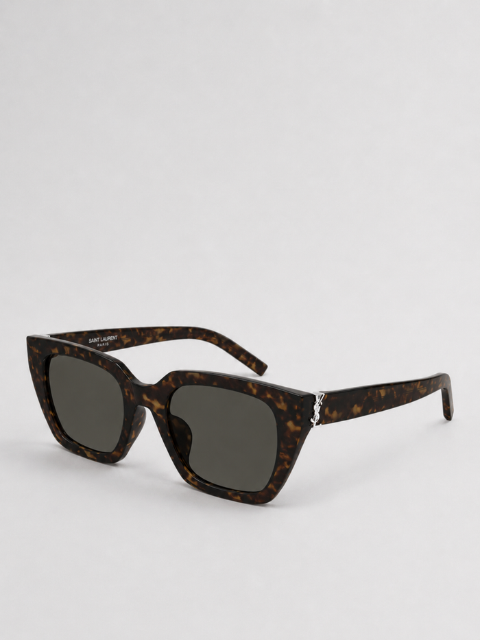 Sunglasses with dark lenses and gray frame on a light beige background